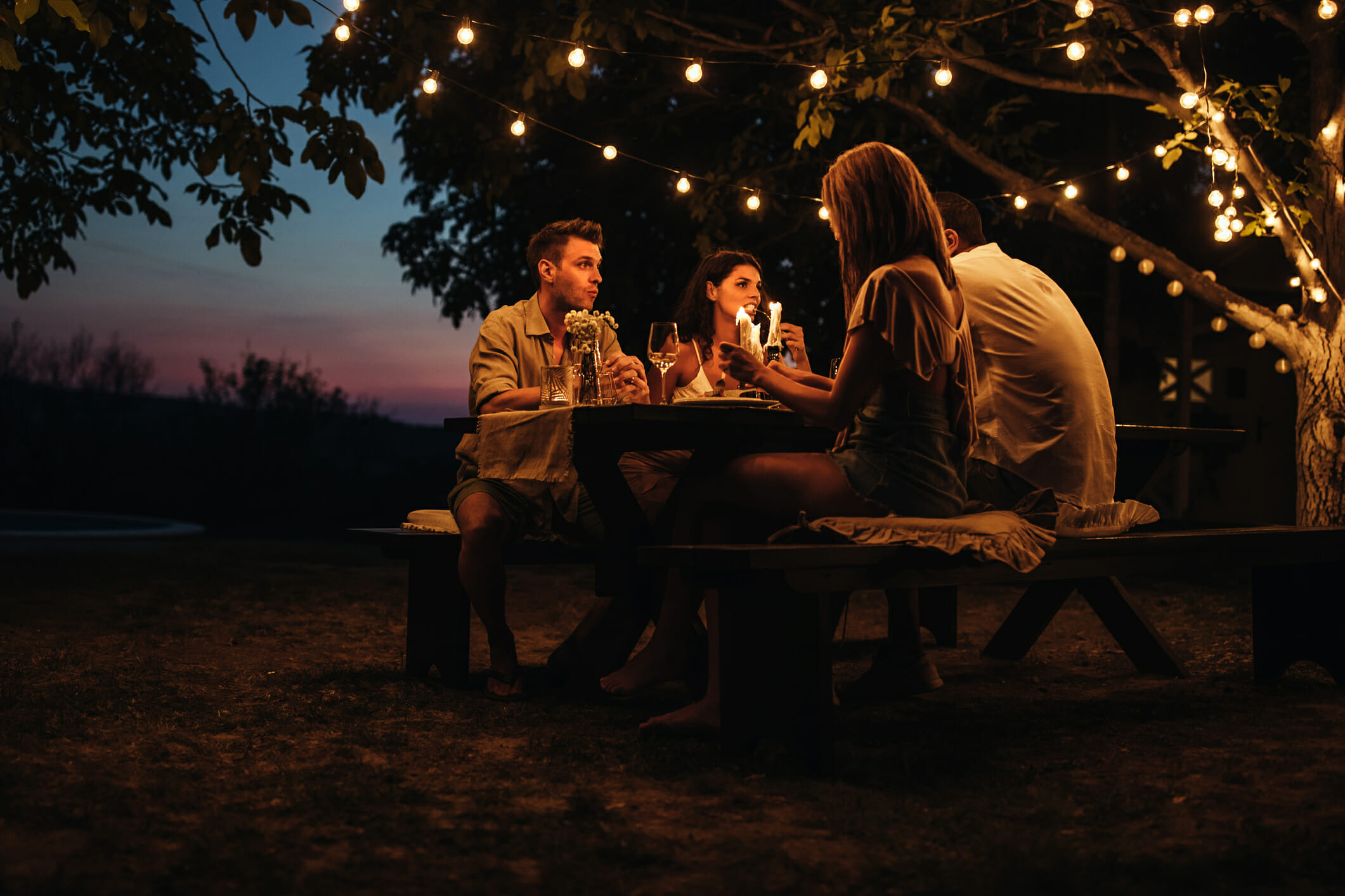 Two couples having a romantic dinner outdoors