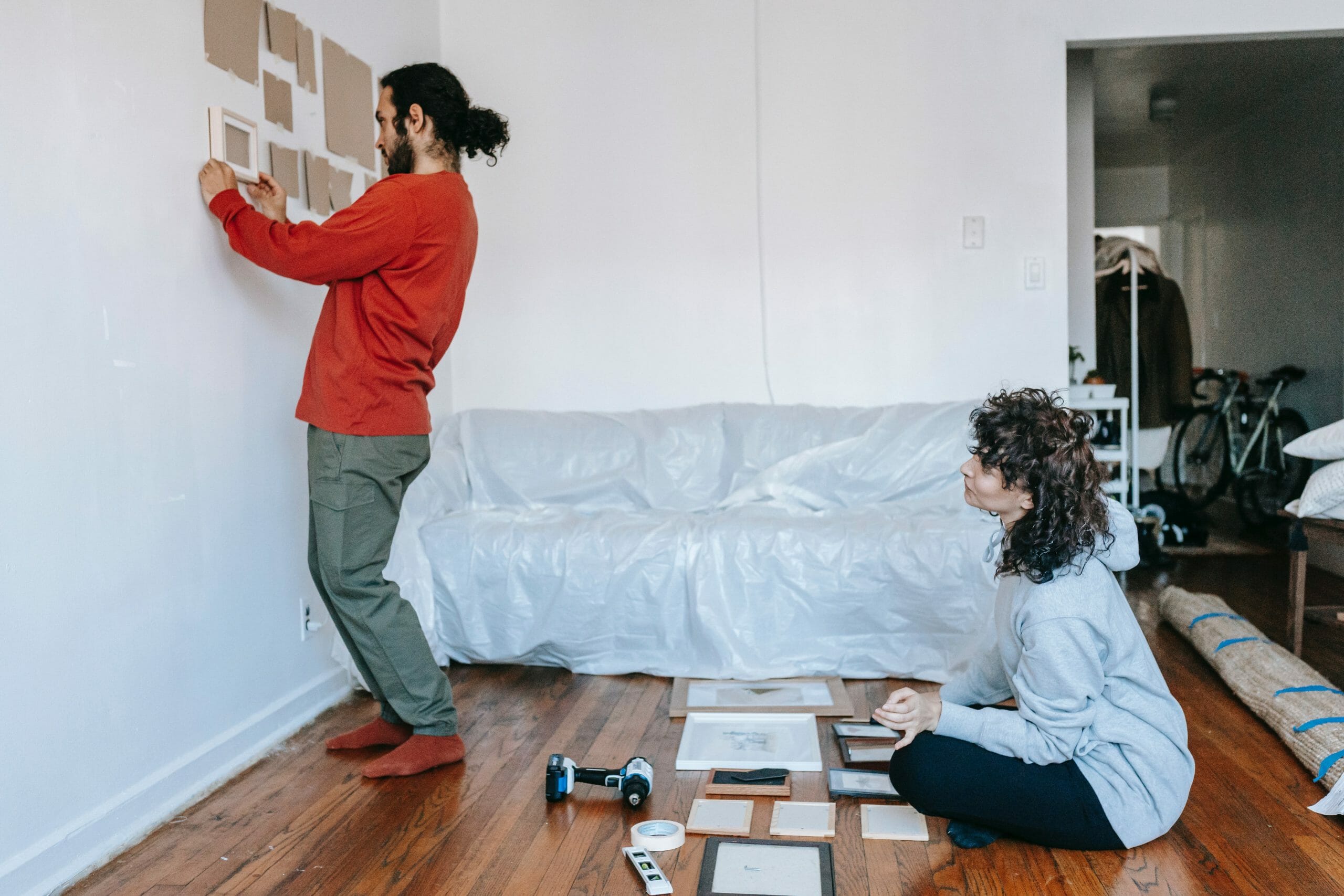 Pareja re decorando la pared de su casa