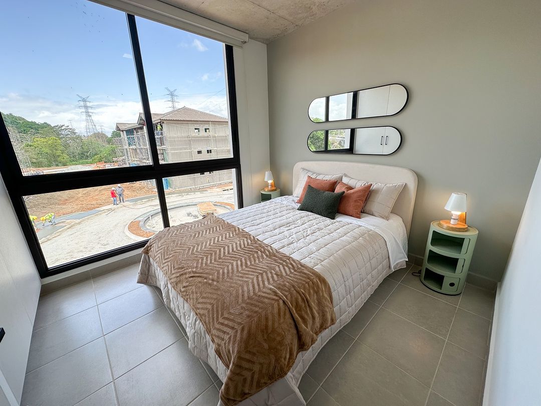 Habitación moderna con amplias ventanas dentro del desarrollo inmobiliario Begin CoLiving en Panamá Norte
