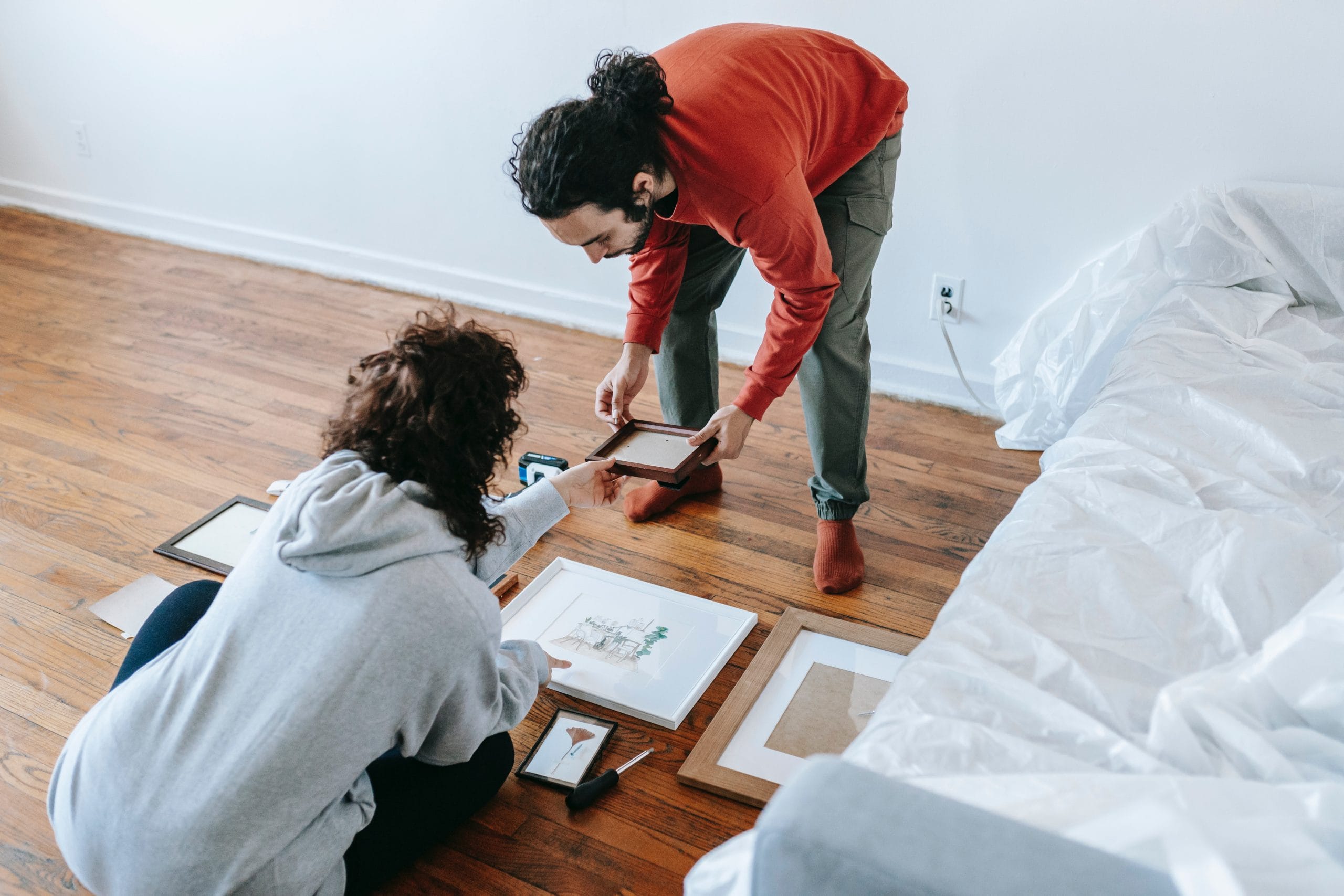 Pareja escogiendo un marco de fotos para decorar sus paredes